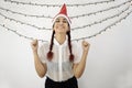 Girl with a red Christmas hat and red hair, with her eyes closed and smiling raising her arms with closed fists, very happy Royalty Free Stock Photo