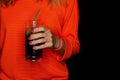 A girl in red clothes holds a glass of alcoholic beverage on black background Royalty Free Stock Photo