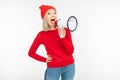 Girl in red clothes with a megaphone in hands shouts on a white background Royalty Free Stock Photo