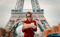 Girl in red coat and bag with map in parisian park Royalty Free Stock Photo