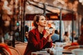 Girl in red coat with cup of coffee in parisian cafe Royalty Free Stock Photo