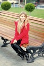 Girl in red coat sit on bench in park Royalty Free Stock Photo