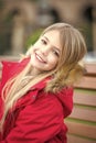 Girl in red coat sit on bench in park Royalty Free Stock Photo
