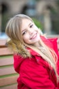 Girl in red coat sit on bench in park Royalty Free Stock Photo