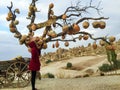 Girl in red coat stand under the Cappadocia famous Pottery tree Royalty Free Stock Photo