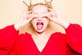 Girl in a red dress on a beige background. A woman eats with chopsticks for sushi, closes her eyes with them and grimaces, smiles Royalty Free Stock Photo