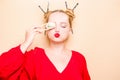 Girl in a red dress on a beige background. A woman eats with chopsticks for sushi, closes her eyes with them and grimaces, smiles Royalty Free Stock Photo