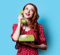 Girl in red dress with green dial phone Royalty Free Stock Photo