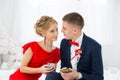 A girl in a red dress with a guy holding a mobile phone. Royalty Free Stock Photo