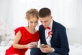 A girl in a red dress with a guy holding a mobile phone. Royalty Free Stock Photo