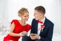 A girl in a red dress with a guy holding a mobile phone. Royalty Free Stock Photo