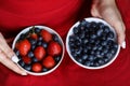 Girl in red dress holding plate of berries. White plate with strawberry and blueberry. Healthy lifestyle. Fruit vitamin. Fruit sal Royalty Free Stock Photo