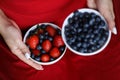 Girl in red dress holding plate of berries. White plate with strawberry and blueberry. Healthy lifestyle. Fruit vitamin. Fruit sal Royalty Free Stock Photo