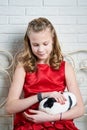 Girl in red dress holding rabbit in her arms Royalty Free Stock Photo