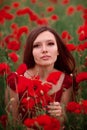 Girl in a red dress on a poppy field Royalty Free Stock Photo