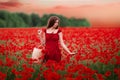 Girl in a red dress on a poppy field Royalty Free Stock Photo