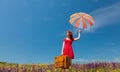 Girl in red dress with umbrella and suitcase Royalty Free Stock Photo