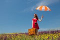 Girl in red dress with umbrella and suitcase Royalty Free Stock Photo