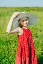 Girl in red dress and white hat with large brim