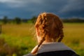 Girl With Red Hair in Braids Walks Through a Field in the Countryside Royalty Free Stock Photo