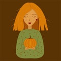 A girl with red hair holds a pumpkin