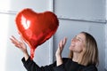 a girl with red heart-shaped balloons smiles and enjoys life. Caucasian woman celebrating valentine& x27;s day. A note to Royalty Free Stock Photo