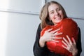 a girl with red heart-shaped balloons smiles and enjoys life. Caucasian woman celebrating valentine& x27;s day. A note to Royalty Free Stock Photo