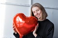 a girl with red heart-shaped balloons smiles and enjoys life. Caucasian woman celebrating valentine& x27;s day. A note to Royalty Free Stock Photo