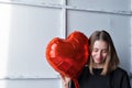 a girl with red heart-shaped balloons smiles and enjoys life. Caucasian woman celebrating valentine& x27;s day. A note to Royalty Free Stock Photo