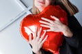 a girl with red heart-shaped balloons smiles and enjoys life. Caucasian woman celebrating valentine& x27;s day. A note to Royalty Free Stock Photo