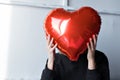 a girl with red heart-shaped balloons smiles and enjoys life. Caucasian woman celebrating valentine& x27;s day. A note to Royalty Free Stock Photo