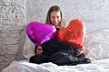 a girl with red heart-shaped balloons smiles and enjoys life. Caucasian woman celebrating valentine& x27;s day. A note to Royalty Free Stock Photo