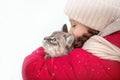 A large labrador dog and a cat in winter on a walk with a young woman in a snowy field Royalty Free Stock Photo