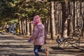 Girl in a red jacket, hat and glasses chasing pigeons in the park Royalty Free Stock Photo