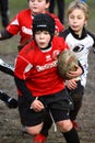 Girl with red jacket play rugby Royalty Free Stock Photo