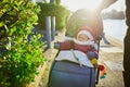 Girl in red jacket and white knitted hat and scarf sitting in pushchair Royalty Free Stock Photo