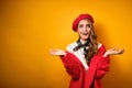 A girl with red lipstick in a red coat and beret is standing and shockingly opening her eyes and mouth, will spread her Royalty Free Stock Photo