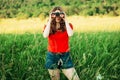 Girl in a red looking through binoculars. woman looking through Royalty Free Stock Photo