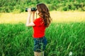 Girl in a red looking through binoculars. woman looking through Royalty Free Stock Photo