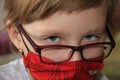 A girl in a red mask and glasses. A hurt child