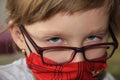 A girl in a red mask and glasses. A hurt child