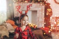 Girl in red pajamas eating cookies in front of christmas background