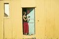 Girl in red pants swats flies with red fly swatter in Cape Town, South Africa Royalty Free Stock Photo