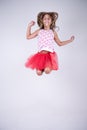 Girl with red skirt jumping happy and smiling with hands up and hair in the wind