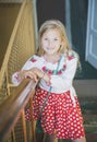 Girl in a red skirt smiling stands on the steps