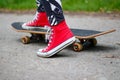 Girl in red sneakers on a skateboard. Feet on a skateboard