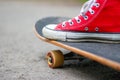 Girl in red sneakers on a skateboard. Feet on a skateboard