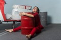 Girl in a red suit. The girl hugs a red barrel.