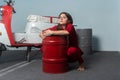 Girl in a red suit. The girl hugs a red barrel.