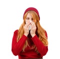 A girl in red sneezes and wipes her nose with her eyes ajar on a white isolated background